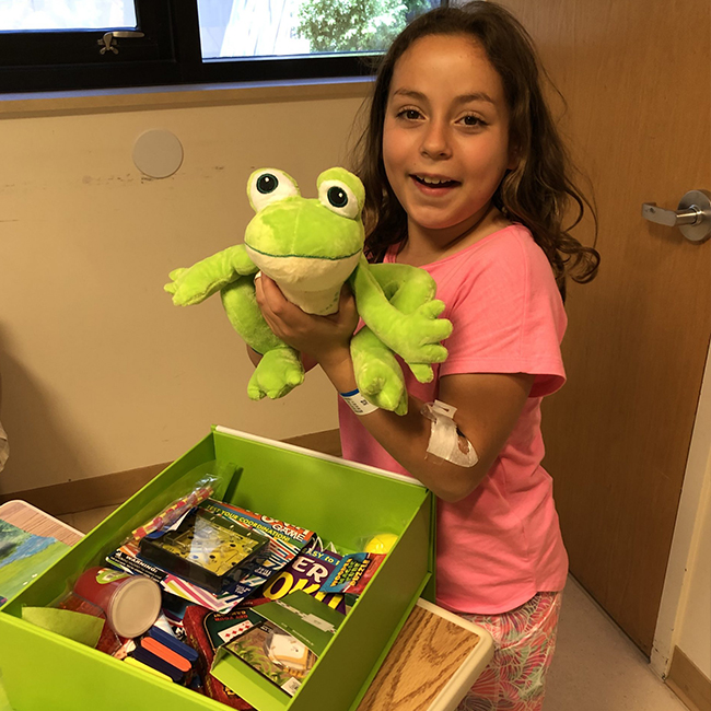 Girl in hospital with Cheeriodicals frog and box
